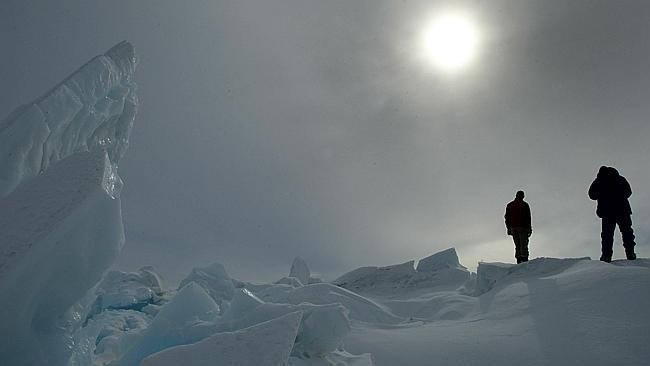 Paul Rogers and Graeme Blick view a partial solar eclipse near New Zealand's Scott Base. P...