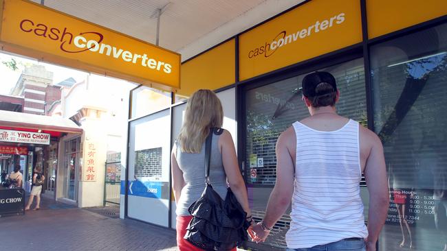 Young couple standing in front of closed Cash Converters store on Gouger Street, Adelaide.