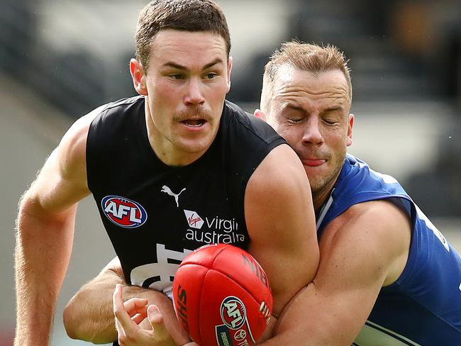 BRISBANE, AUSTRALIA - JULY 25: Mitch McGovern of the Blues is tackled by Josh Walker of the Kangaroos during the round 8 AFL match between the North Melbourne Kangaroos and the Carlton Blues at The Gabba on July 25, 2020 in Brisbane, Australia. (Photo by Jono Searle/AFL Photos/via Getty Images)