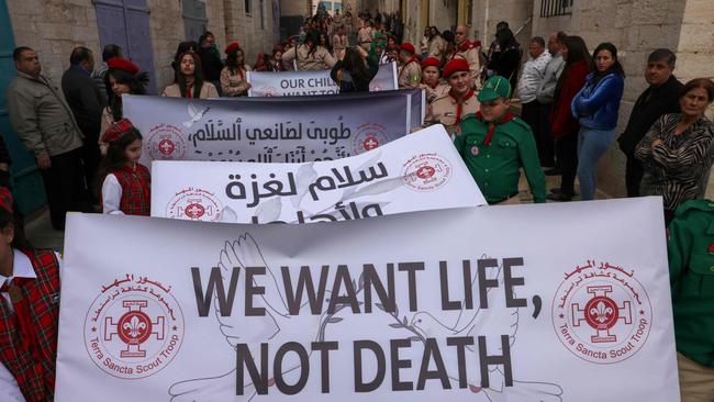 Palestinian scouts lift banners as they partake in the yearly Christmas procession towards the Church of the Nativity in Bethlehem town in the Israel-occupied West Bank on December 24, 2024. Picture: AFP