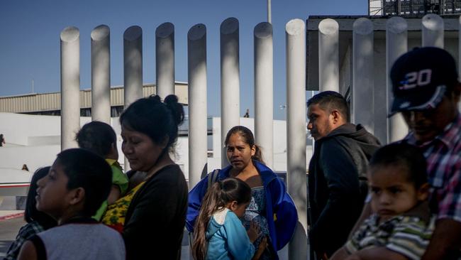 Migrants from Honduras wait in line at the Mexico-United States border crossing in Tijuana. Picture: AFP