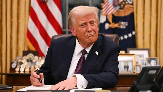 US President Donald Trump signs executive orders in the Oval Office on Tuesday. Picture: AFP