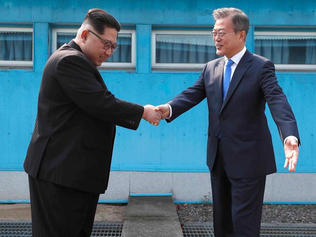 North Korean leader Kim Jong-un, left, shakes hands with South Korean President Moon Jae-in over the military demarcation line last month.