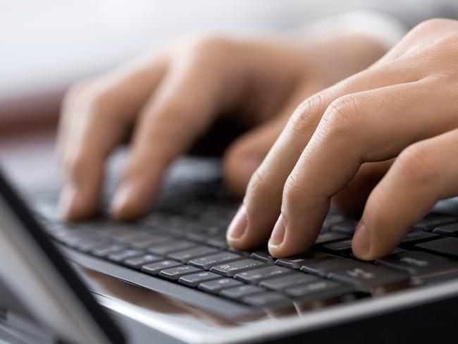 Close-up of male fingers typing a business document on the black laptop