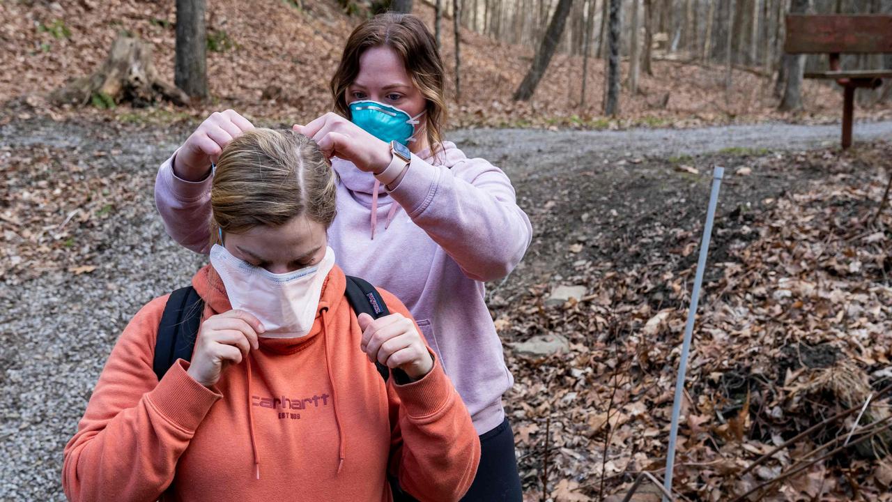 Olivia Holley, 22, and Taylor Gulish, 22, put PPE on before collecting water samples from Leslie Run creek on February 25. Picture: Michael Swensen / Getty Images via AFP