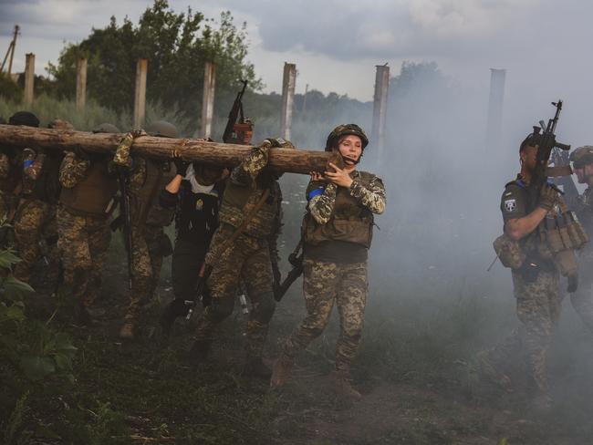 Smoke filled the air as the women muscled through another task. Picture: Ercin Erturk/Anadolu Agency via Getty Images