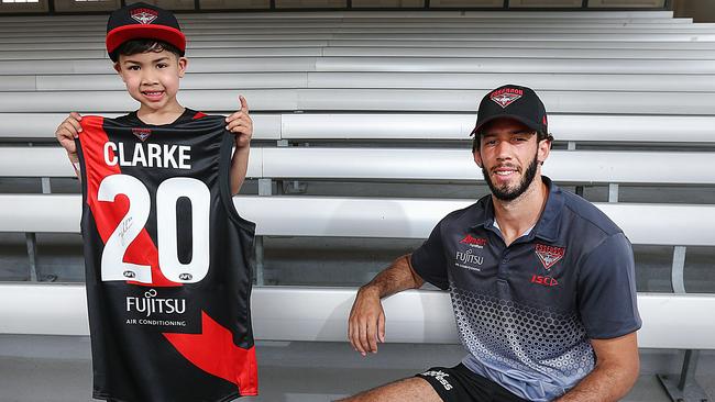 Essendon recruit Zac Clarke is presented with his jumper by young fan Eugene, 4, at the club’s family day at Melbourne Showgrounds. Picture: Ian Currie