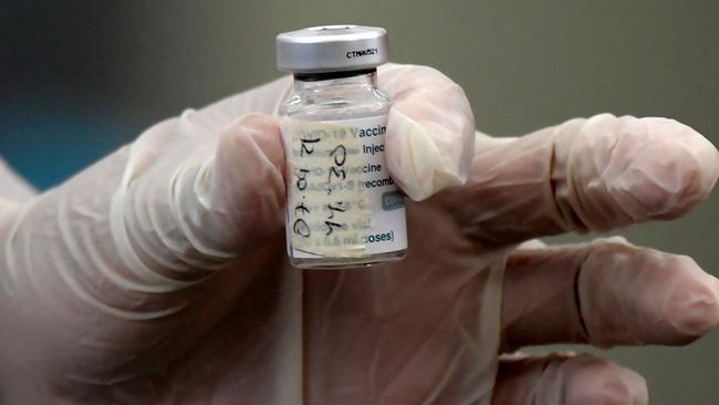 A health worker prepares a Oxford/AstraZeneca vaccine against COVID-19. (Photo by Raul ARBOLEDA / AFP)