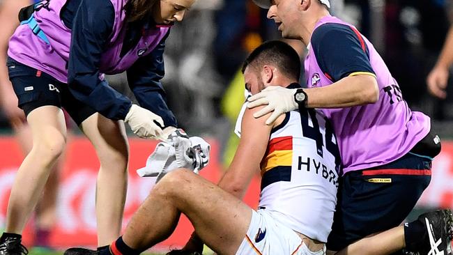 Lachlan Murphy of the Crows is helped by trainers last night. Picture: Bradley Kanaris/Getty Images