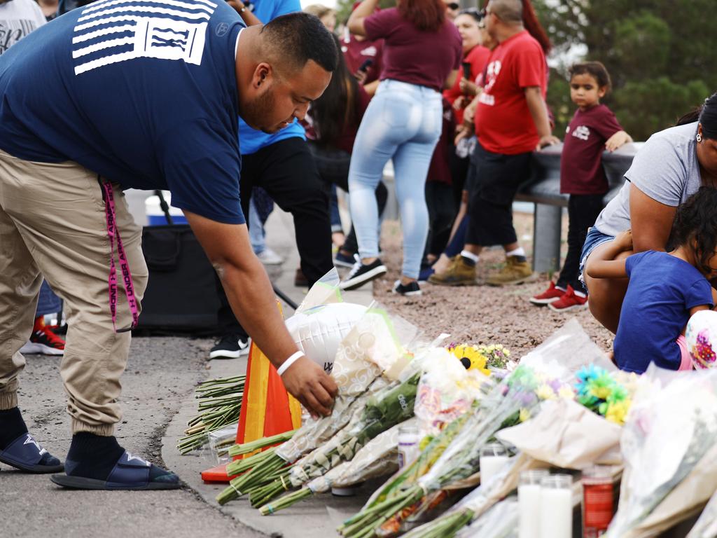 People leave flowers at a makeshift memorial outside Walmart, near the scene of the mass shooting which left at least 20 people dead. Picture: AFP