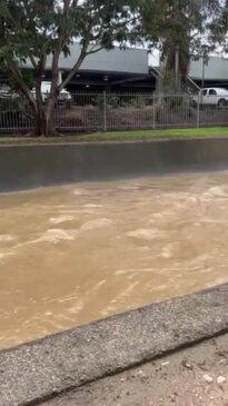 Water rushing fast down a drain behind Hinkler Shopping Centre