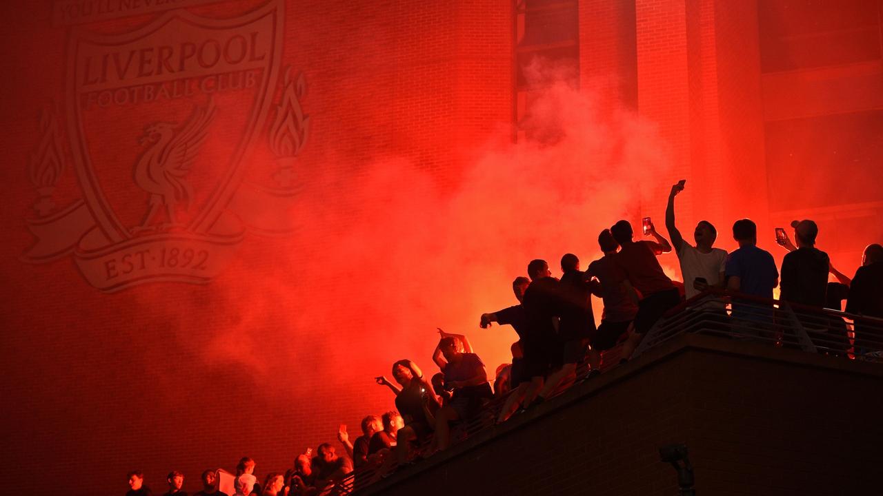 Fans celebrate outside Anfield. (Photo by Oli SCARFF / AFP)