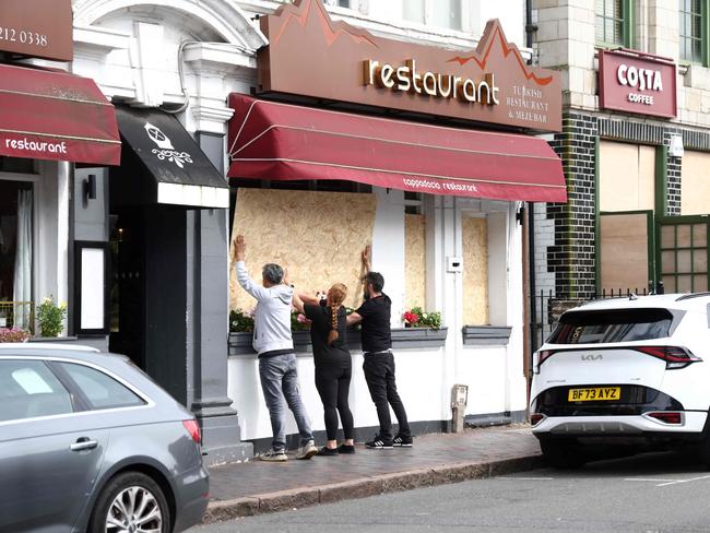 People board up a restaurant ahead of an anti-immigration protest called by far-right activists in Birmingham. Picture: AFP