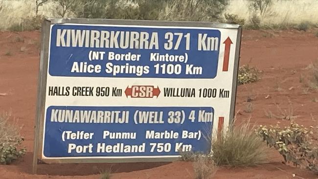 A sign near Kunawarritji shows the distances to the nearest regional centres of Port Hedland or Alice Springs.