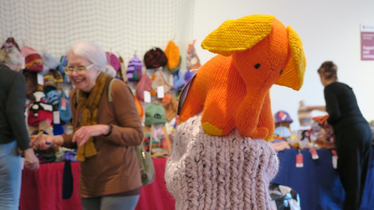 Dozens of volunteers are busy hanging thousands of beanies in preparation for the 28th Alice Springs Beanie Festival. Picture: Gera Kazakov