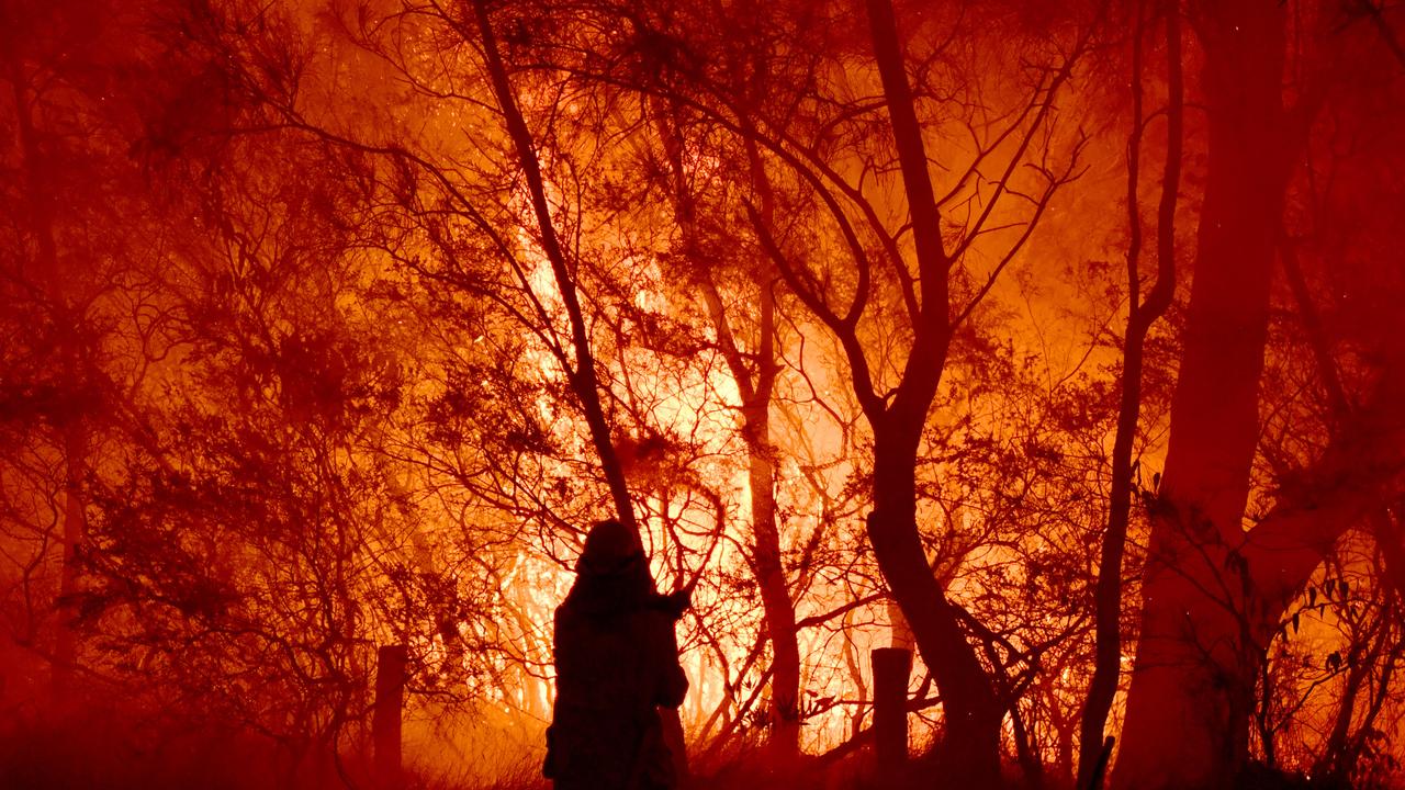 RFS, NSW Fire and Rescue, NPWS officers and local residents fight a bushfire encroaching on properties near Kioloa, between Bateman's Bay and Ulladulla, south of Sydney, in December 2019. Picture: AAP Image/Dean Lewins