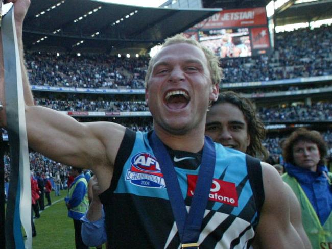 Footballer Kane Cornes with brother Chad holding Premiership cup trophy after win. AFL football - Brisbane Lions vs Port Adelaide Power grand final match at MCG 25 Sep 2004. /Football/AFL