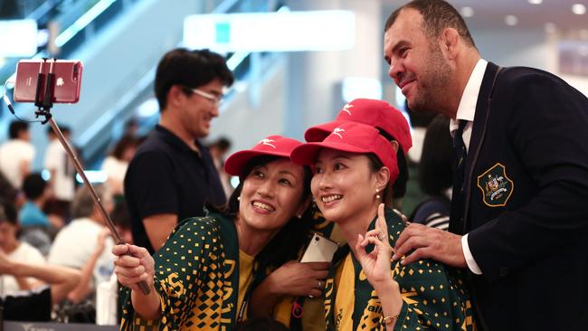 Michael Cheika poses for a selfie with Wallabies fans after his arrival at Haneda Airport.