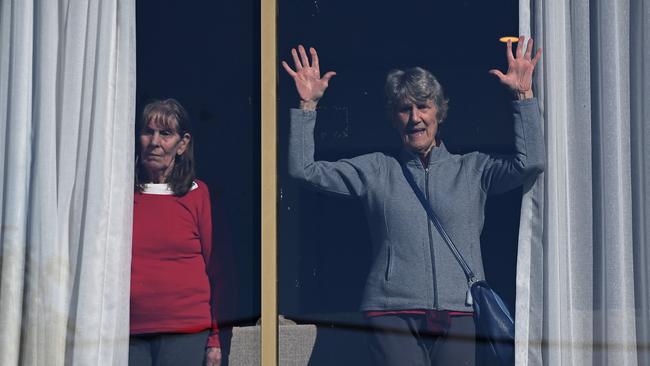 Isolated residents in the SummitCare nursing home in Baulkham Hills, Sydney, wave from inside their room at the height of Covid lockdowns. Picture: NCA NewsWire / Bianca De Marchi