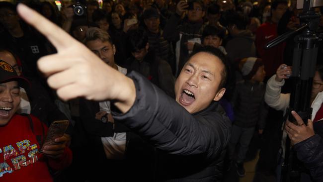 Pro-China counter protesters gesture towards Hong Kong democracy demonstrators during a rally at the State Library in Melbourne.