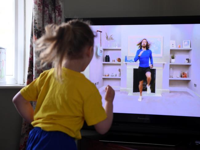 NEWCASTLE UNDER LYME, UNITED KINGDOM - MARCH 23: Four-year-old Lois Copley-Jones takes part in a live streamed broadcast of PE with fitness trainer Joe Wicks on the first day of the nationwide school closures on March 23, 2020 in Newcastle Under Lyme, United Kingdom. Coronavirus (COVID-19) pandemic has spread to at least 182 countries, claiming over 10,000 lives and infecting hundreds of thousands more. (Photo by Gareth Copley/Gareth Copley)