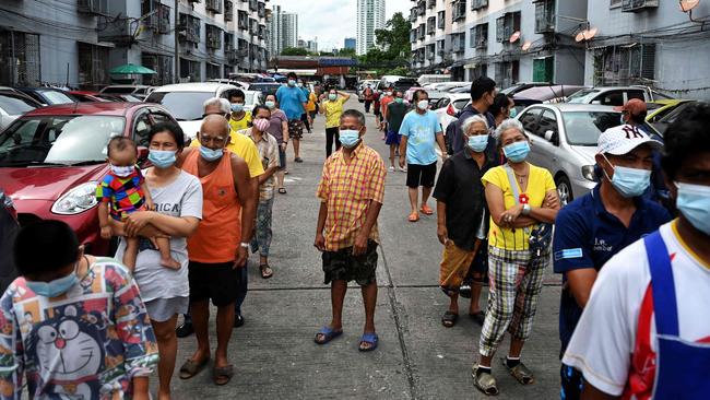 Residents of a slum district in Bangkok queue for food boxes as food security among the poorest communities continues to free-fall due to Covid-19. Picture: AFP