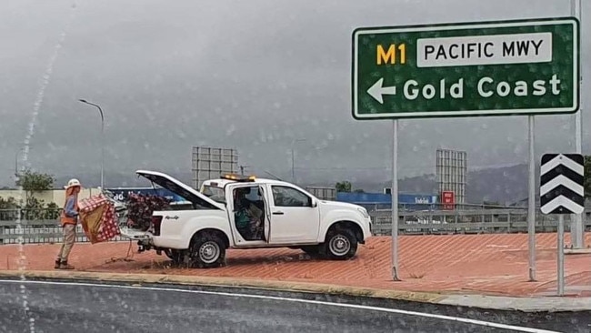 A TMR worker packing up the Christmas tree that was placed by the tinsel bombers at the Oxenford overpass. Photo supplied by Gold Coast Community Facebook Page.