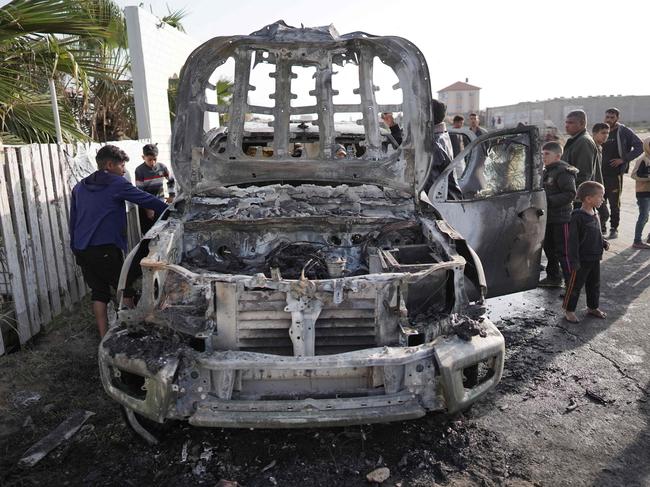 People gather around the car of the US-based aid group World Central Kitchen that was hit by an Israeli strike the previous day in Deir al-Balah in the central Gaza Strip. Picture: AFP