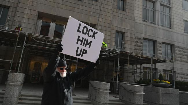 A man holds a placard outside the FBI’sWashington office in Washington, DC before a scheduled court appearance of Former Donald Trump adviser Steve Bannon to face charges after refusing to cooperate with the investigation into the deadly Jan. 6 attack on the US Capitol.