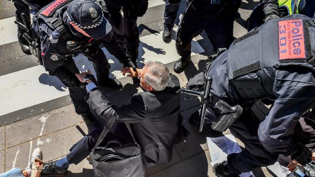 A man is knocked to the ground as climate change activists blockade the IMARC conference at the Melbourne Exhibition Centre last week. Picture: Jake Nowakowski