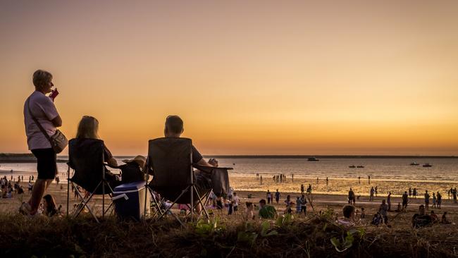 Visitors relax on the beach as the sun sets at Darwin's famous Mindil Beach Sunset Markets. Picture: Tourism NT