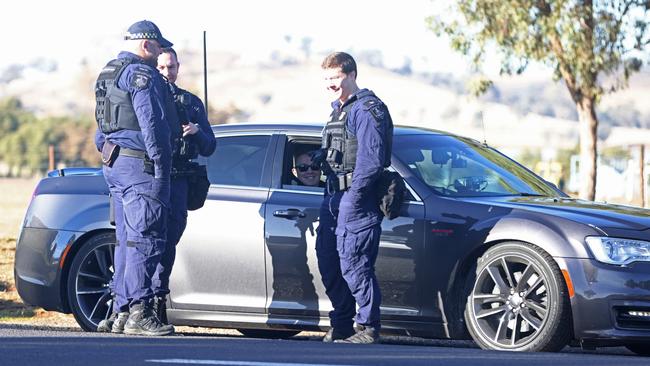 NSW Police and Corrective Services officers wait outside the prison before providing an escort for Hamzy on his way back to Sydney.