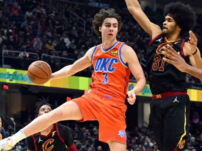 CLEVELAND, OHIO - JANUARY 22: Josh Giddey #3 of the Oklahoma City Thunder passes around Jarrett Allen #31 of the Cleveland Cavaliers during the second quarter at Rocket Mortgage Fieldhouse on January 22, 2022 in Cleveland, Ohio. NOTE TO USER: User expressly acknowledges and agrees that, by downloading and/or using this photograph, user is consenting to the terms and conditions of the Getty Images License Agreement. (Photo by Jason Miller/Getty Images)