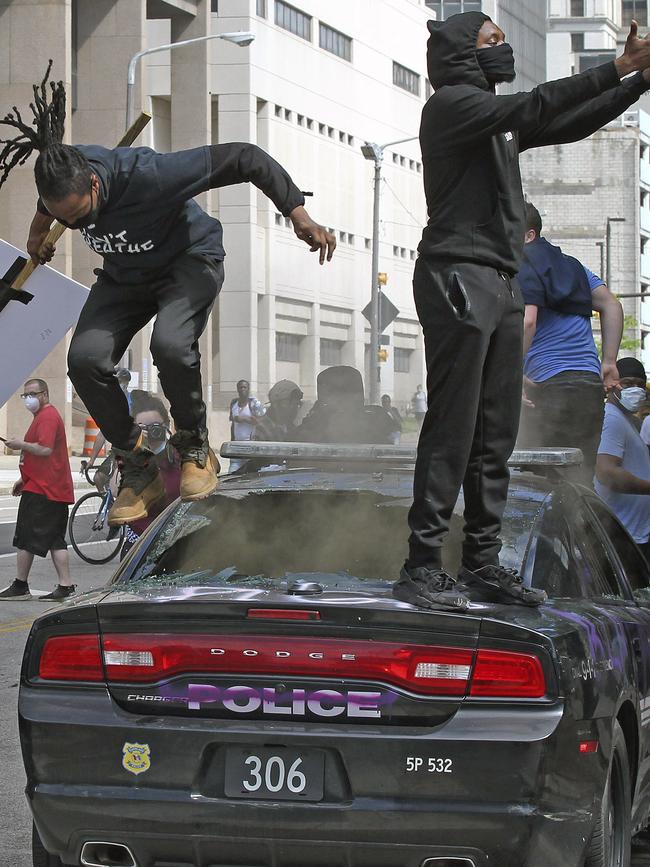 Protesters stomp on a Cleveland police cruiser on Saturday. Picture John Kuntz