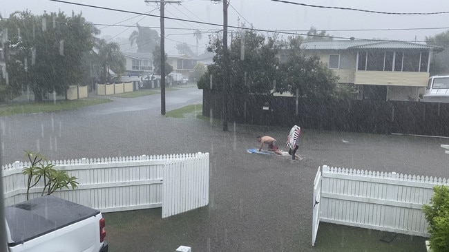 People take to the streets of Clontarf to body board in floodwaters after flash flooding hit the area. Picture: Cas Garvey