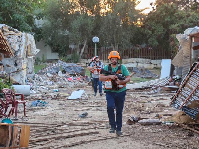 Armed rescuers search the scene of an attack in Kfar Aza. Picture: Gil Cohen-Magen/AFP