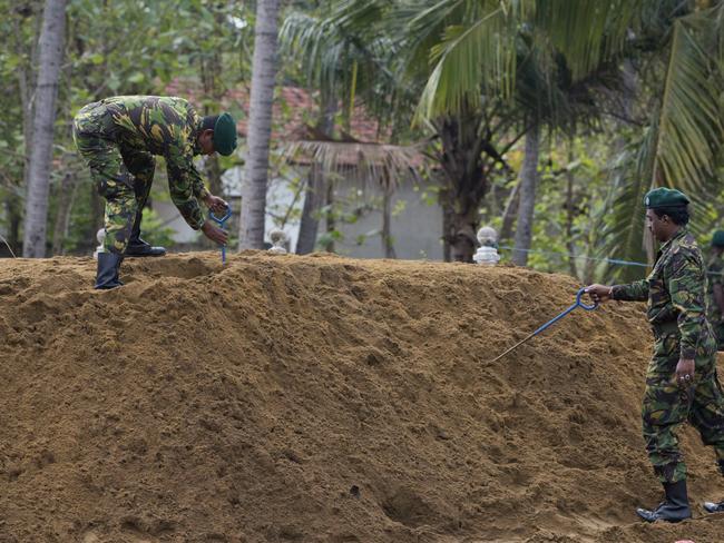 Officers of Special Task Force search for explosives ahead of mass burials  in Negombo, Sri Lanka.