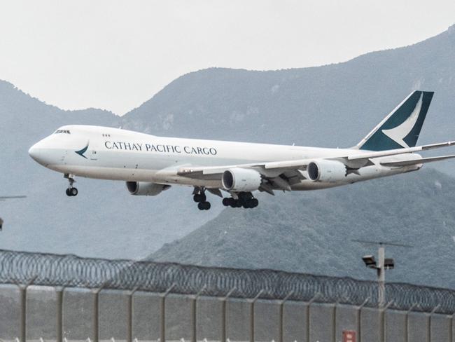 (FILES) This file photo taken on November 21, 2021 shows a Cathay Pacific cargo plane landing at Hong Kong International Airport. - Hong Kong carrier Cathay Pacific on March 9, 2022 posted a loss of 703 million USD for last year, a massive improvement on the record 2.76 billion USD suffered in 2020 even as the airline struggled with continued travel restrictions. (Photo by Bertha WANG / AFP)
