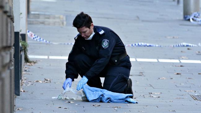 Police cleaning up the crime scene where gangster Bilal Hamze was executed by a gunman on Bridge st in the city of on the 18 June. Picture: Adam Yip