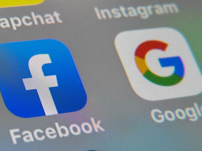 (FILES) This file picture taken on October 1, 2019 shows the logos of mobile apps Facebook and Google displayed on a tablet in Lille. - Australia announced on April 20, 2020 it will begin forcing Google and Facebook to pay news companies for content, in a landmark move aimed at shielding traditional media from the tech giants' digital dominance. (Photo by DENIS CHARLET / AFP)