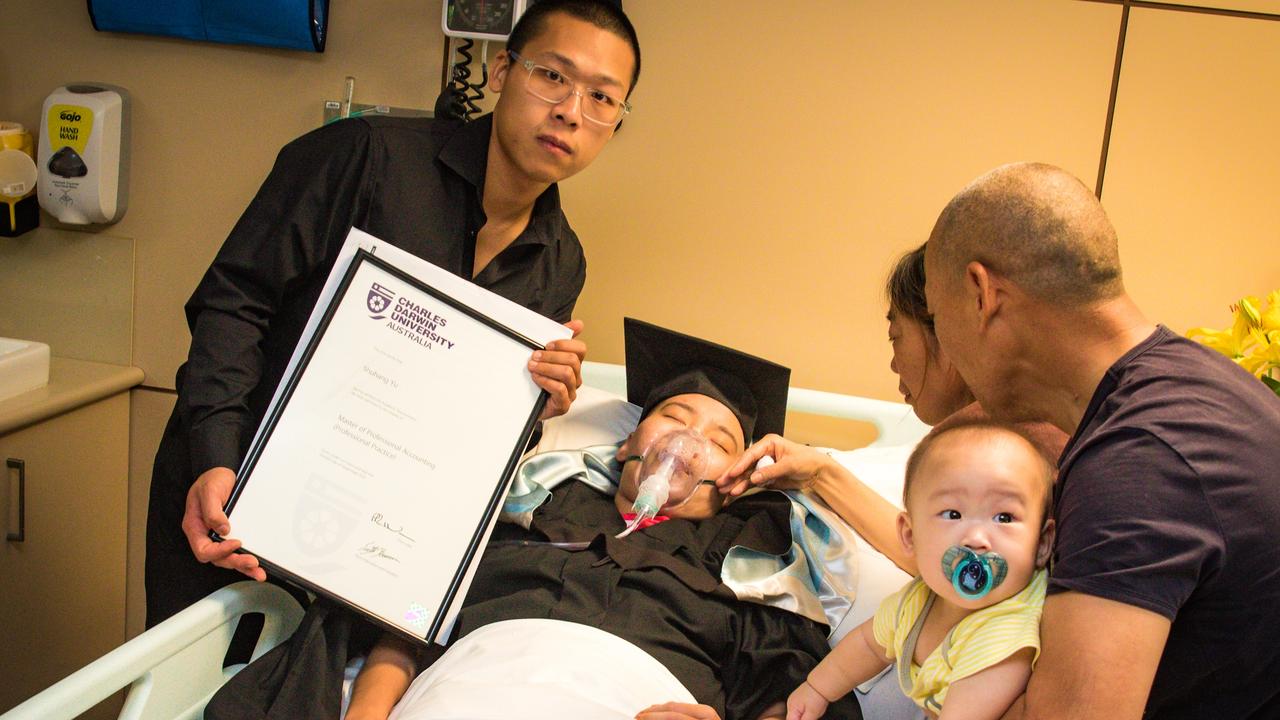 Anna Yu’s husband Will holds her degree alongside her parents and her baby Sunny. Picture: NCA NewsWire/ Glenn Campbell