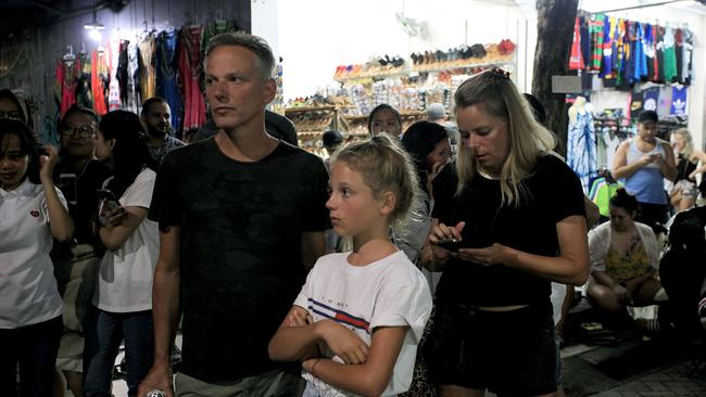 Foreign tourists stand on the street afer being evacuated in Bali. Picture: AFP