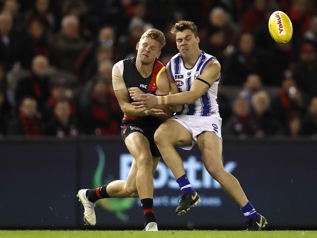 MELBOURNE, AUSTRALIA – JULY 13: Michael Hurley of the Bombers receives a heavy bump from Cameron Zurhaar of the Kangaroos during the 2019 AFL round 17 match between the Essendon Bombers and the North Melbourne Kangaroos at Marvel Stadium on July 13, 2019 in Melbourne, Australia. (Photo by Dylan Burns/AFL Photos via Getty Images)