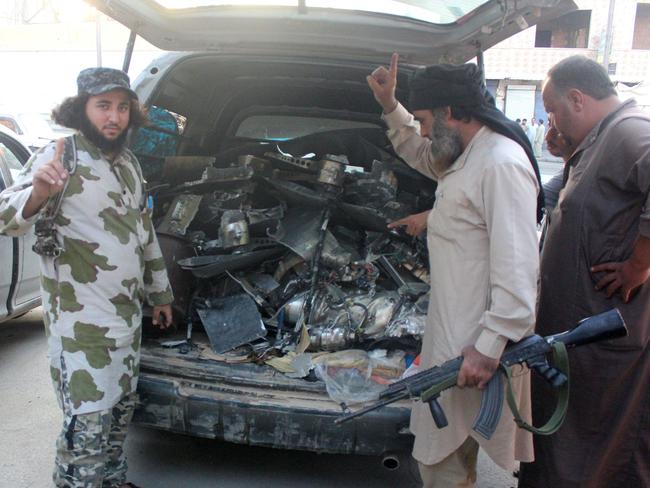 Fighters from the Islamic State group gesture as they load a van with parts that they said was a US drone that crashed into a communications tower in Raqqa early on September 23, 2014.