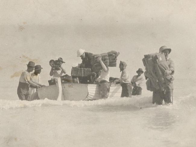 Men from the Wallal expedition unloading a small boat at Eighty Mile Beach in 1922.