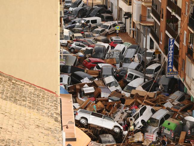 Cars are piled in the street with other debris in the Sedava area of Valencia, Spain. Picture: /Getty Images