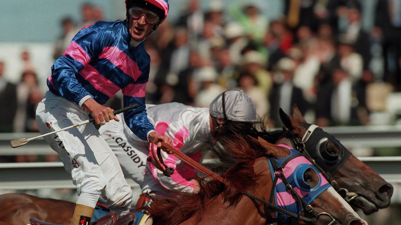 Horseracing - racehorse Doriemus (outside) ridden by jockey Greg Hall standing in saddle with Might and Power (rails) ridden by jockey Jim Cassidy winning 1997 Melbourne Cup race. a/ct might/and/power /Horseracing/Melbourne/Cup