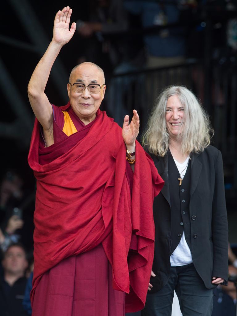 The Dalai Lama waves to the crowd during singer Patti Smith’s performance at the 2015 Glastonbury Festival. Picture: AAP