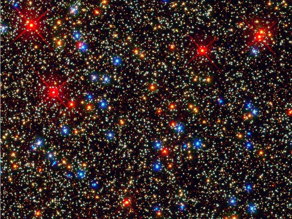 A Hubble panoramic view of a colorful assortment of 100,000 stars residing in the crowded core of a giant star cluster. The image reveals a small region inside the massive globular cluster Omega Centauri, which boasts nearly 10 million stars.