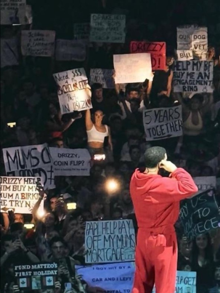 Others say Drake’s shirt could be referencing people bringing in posters asking for money from the billionaire, as seen in his Sydney performances prior.